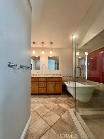 a large bathroom with a tub a sink and a mirror
