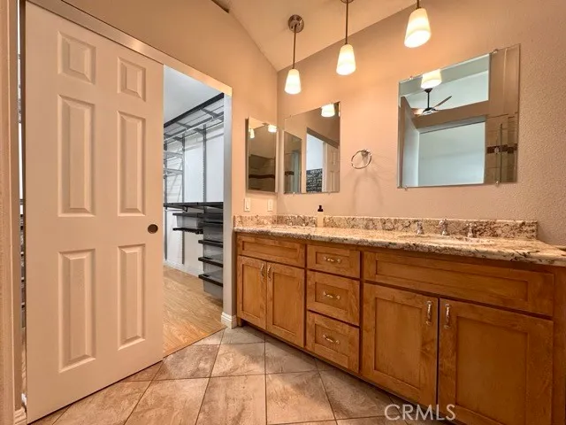 a spacious bathroom with a granite countertop sink and a mirror