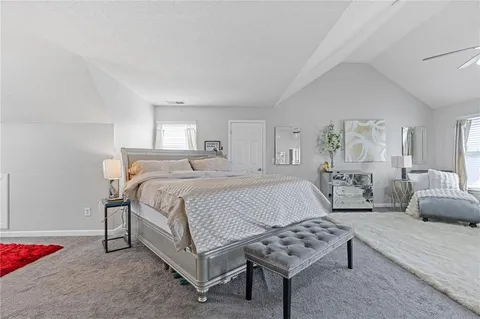 a bedroom with a bed a couch and dresser