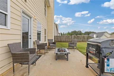 a view of a patio with table and chairs with wooden floor and fence