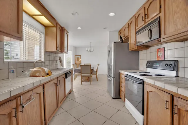 a kitchen with stainless steel appliances granite countertop a stove a sink and a refrigerator
