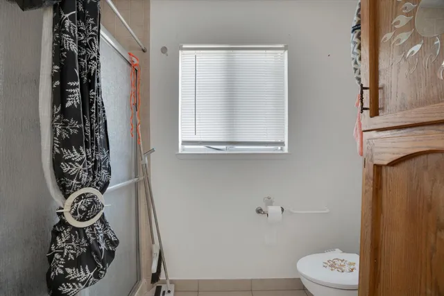 a bathroom with a toilet and a shower curtain