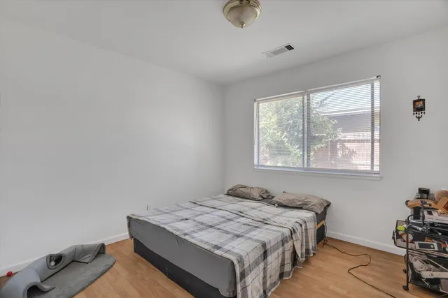a bedroom with a bed and wooden floor