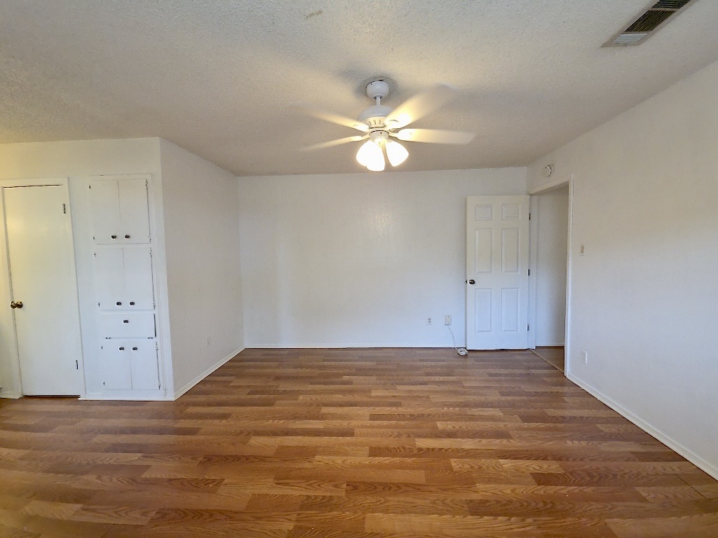 4901 Wing Road Austin, TX 78749 - Photo 13 of 28 Spacious interior featuring wood-finish flooring, white walls, and a ceiling fan with integrated lighting