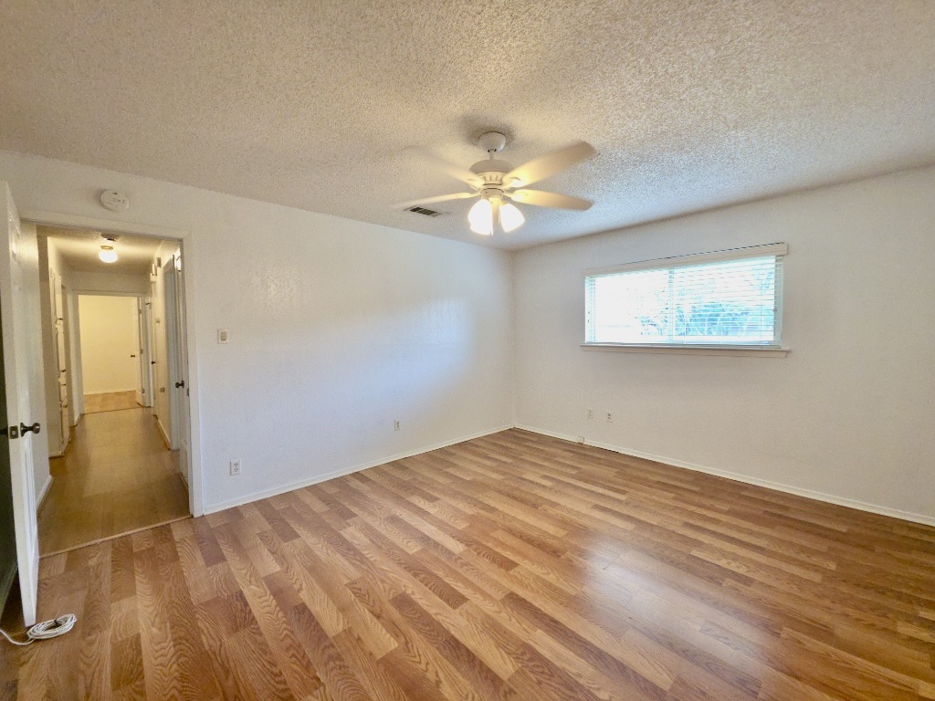 4901 Wing Road Austin, TX 78749 - Photo 14 of 28 Spacious interior featuring wood-finish flooring, white walls, and a ceiling fan with integrated lighting
