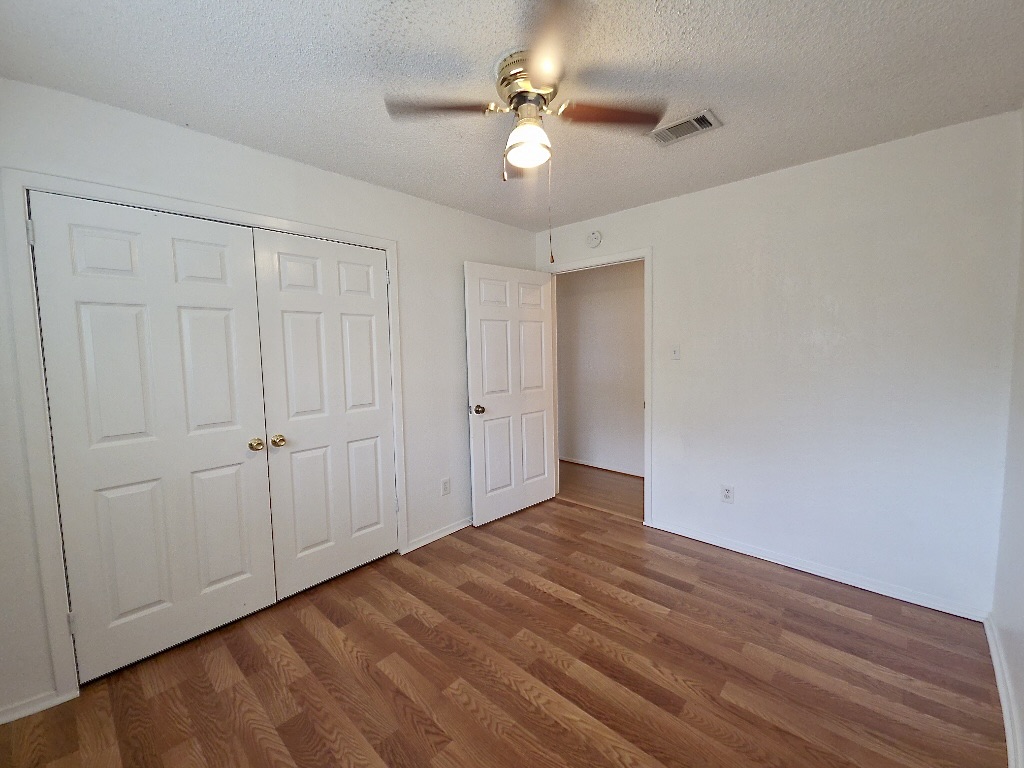 4901 Wing Road Austin, TX 78749 - Photo 19 of 28 Interior room featuring wood-finish flooring, a ceiling fan with integrated lighting, and white walls