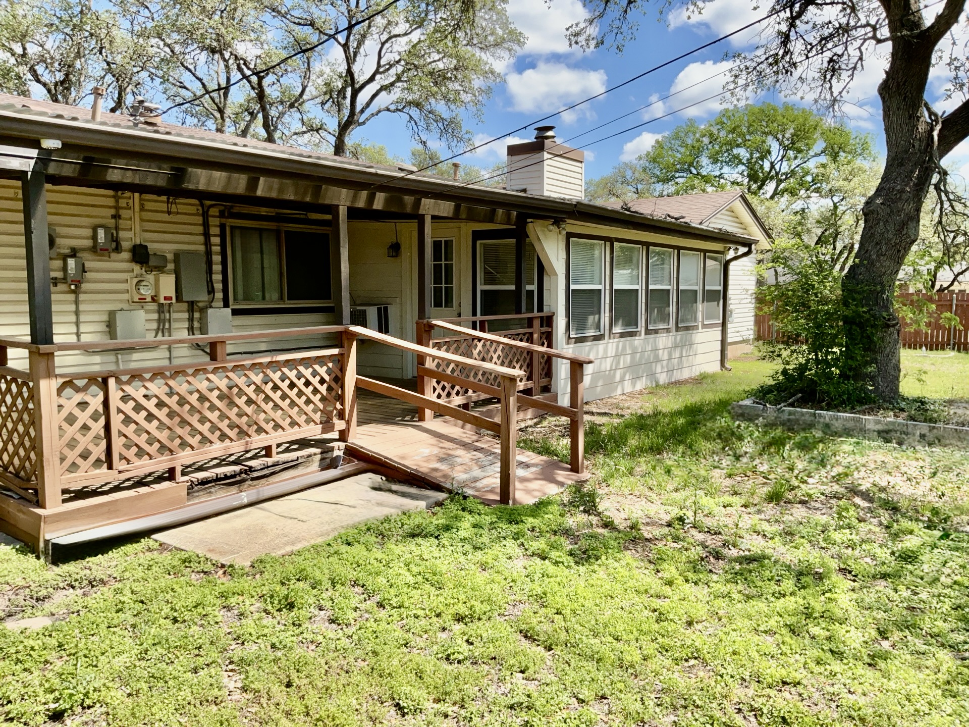 4901 Wing Road Austin, TX 78749 - Photo 27 of 28 Rear exterior featuring an expansive wooden deck with lattice railing and an integrated ramp