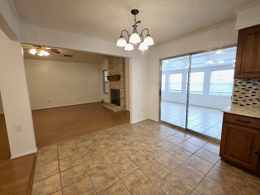 4901 Wing Road Austin, TX 78749 - Photo 4 of 28 Tiled flooring in the dining area with a four-light chandelier