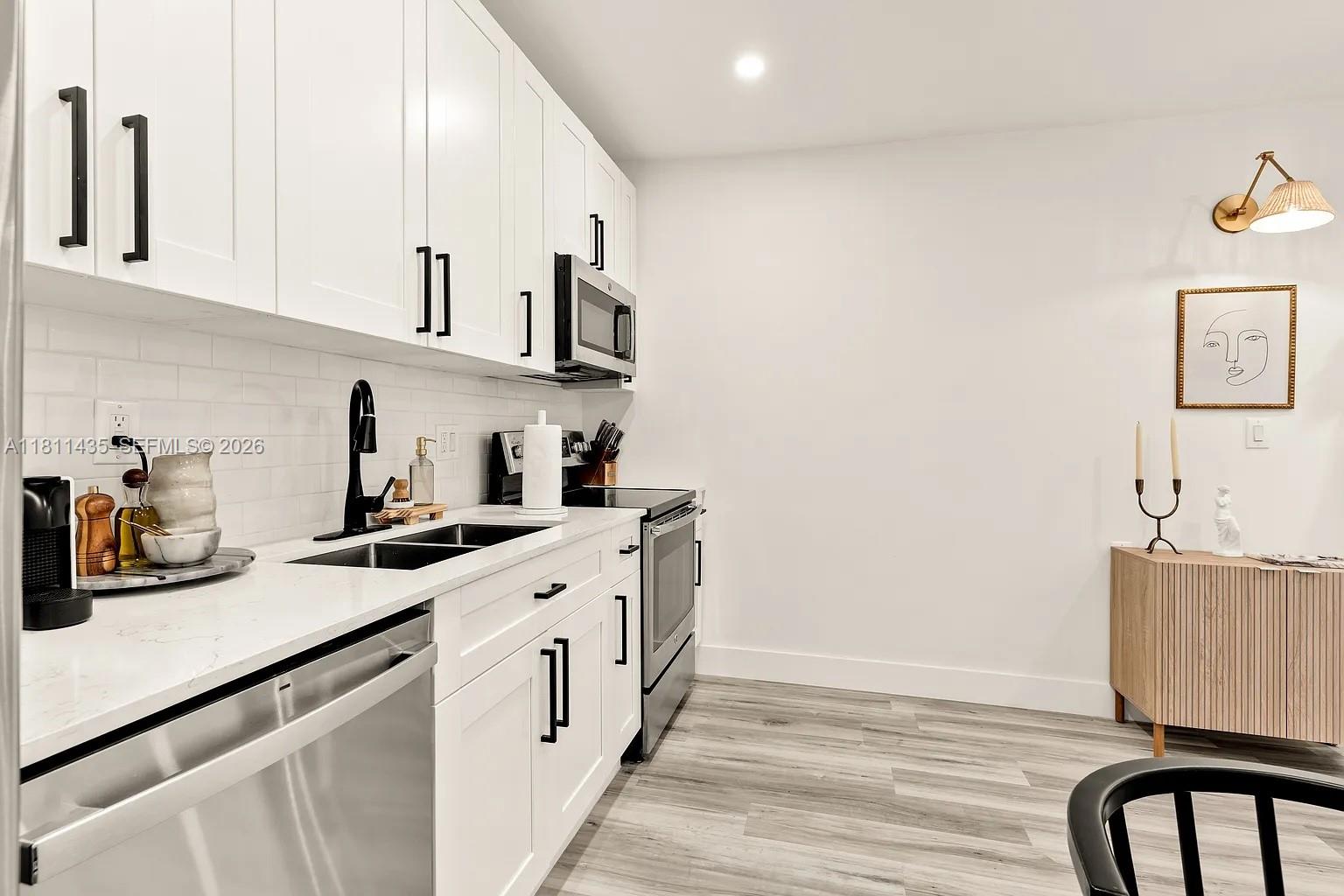 1237 Northwest 33rd Avenue Miami, FL 33125 - Photo 28 of 35 a kitchen with stainless steel appliances a sink a stove a refrigerator and cabinets