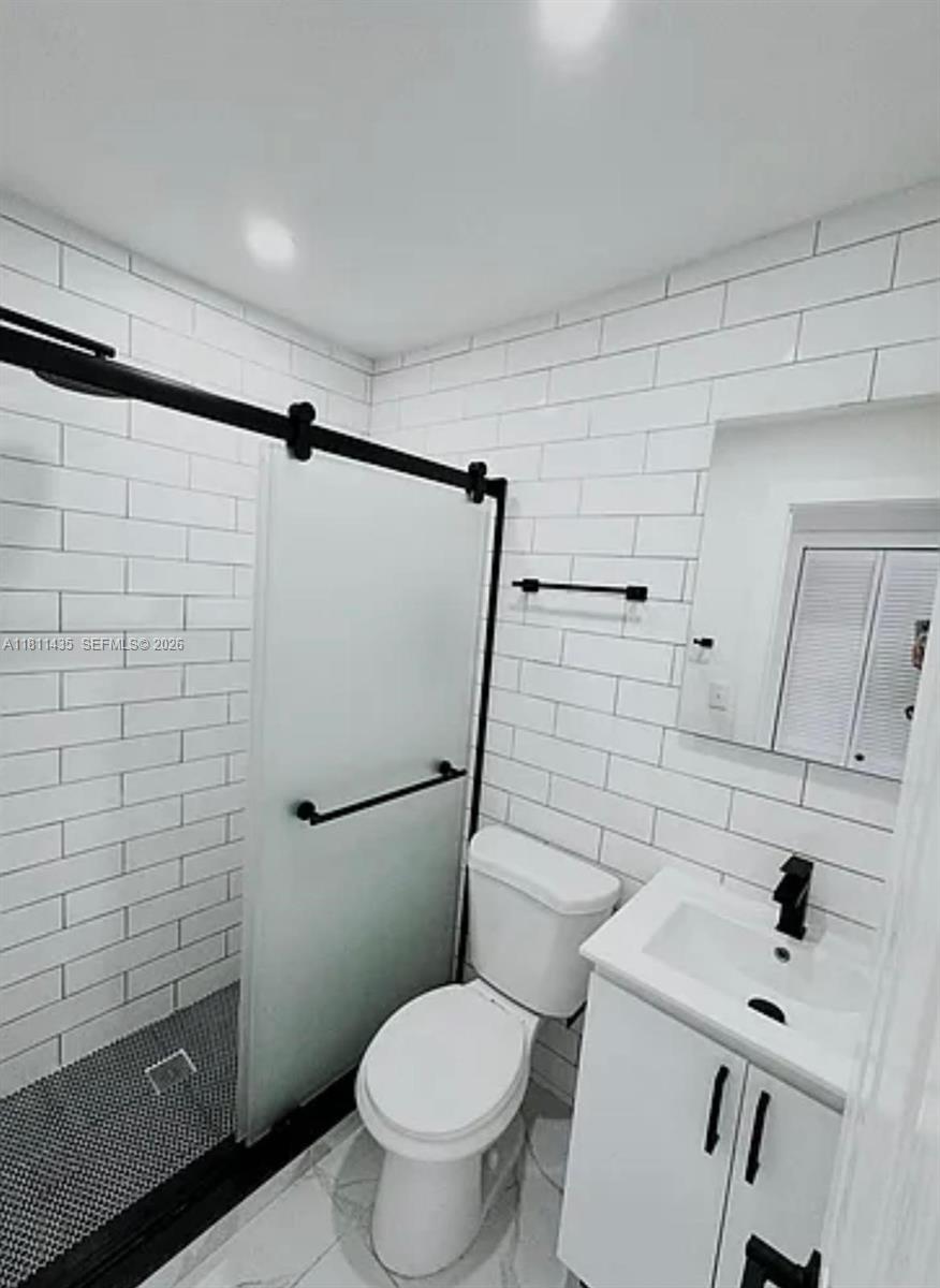 1237 Northwest 33rd Avenue Miami, FL 33125 - Photo 9 of 35 a white toilet sitting next to a bathroom sink