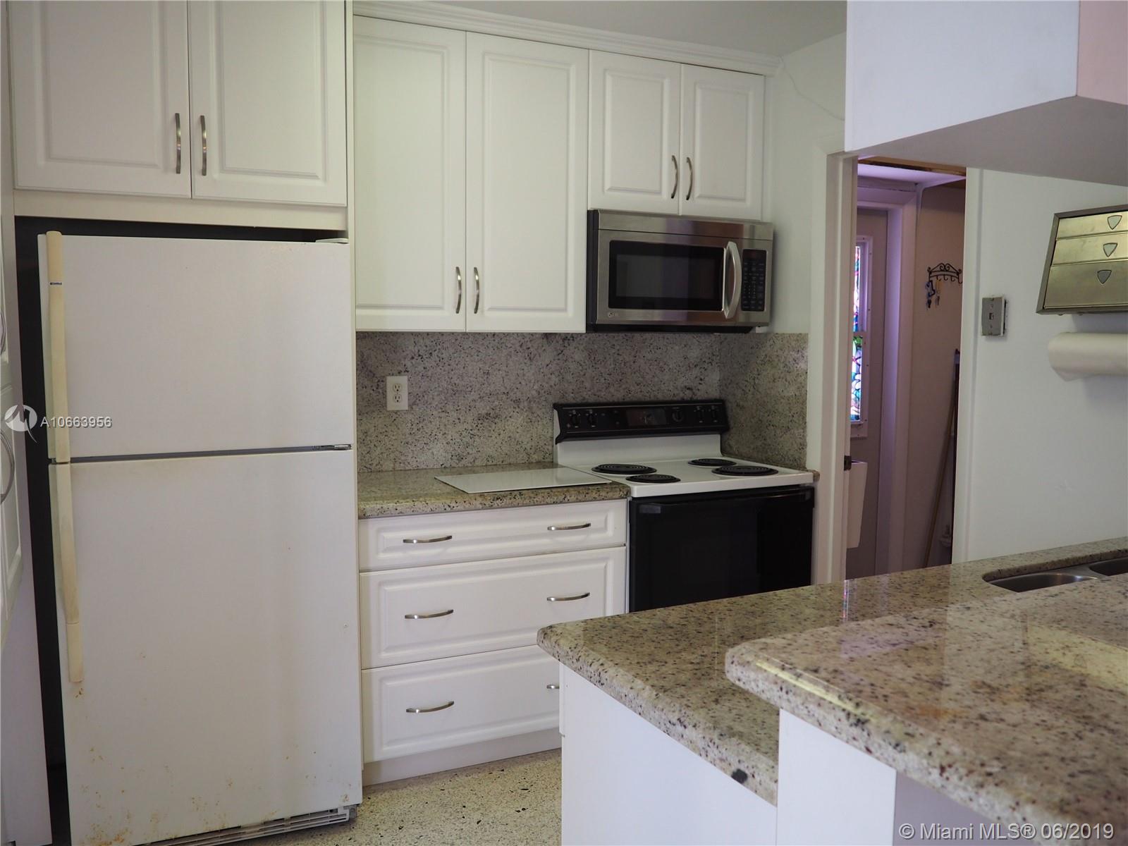 180 Northwest 59th Court Miami, FL 33126 - Photo 4 of 28 Kitchen features Granite Counter Tops and custom cabinetry and access to a large laundry room.