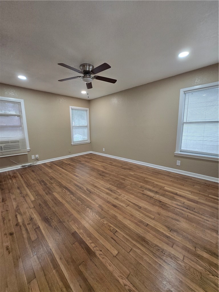 918 Stirman Street Corpus Christi, TX 78411 - Photo 12 of 13 an empty room with wooden floor ceiling fan and windows