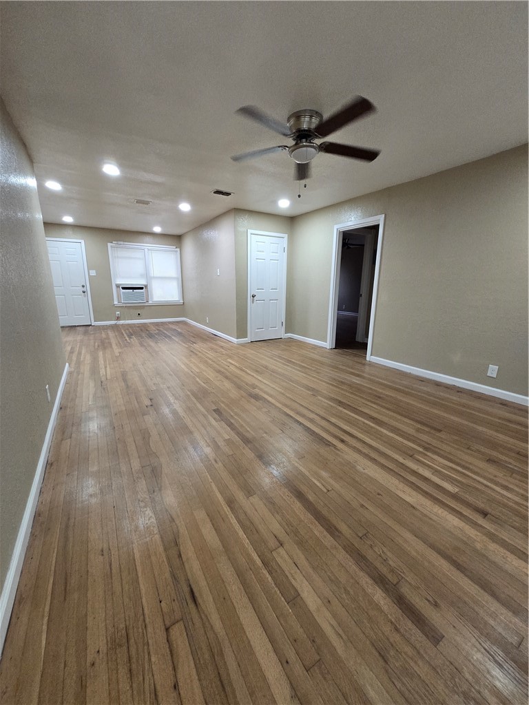 918 Stirman Street Corpus Christi, TX 78411 - Photo 3 of 13 a view of an empty room with wooden floor and a ceiling fan
