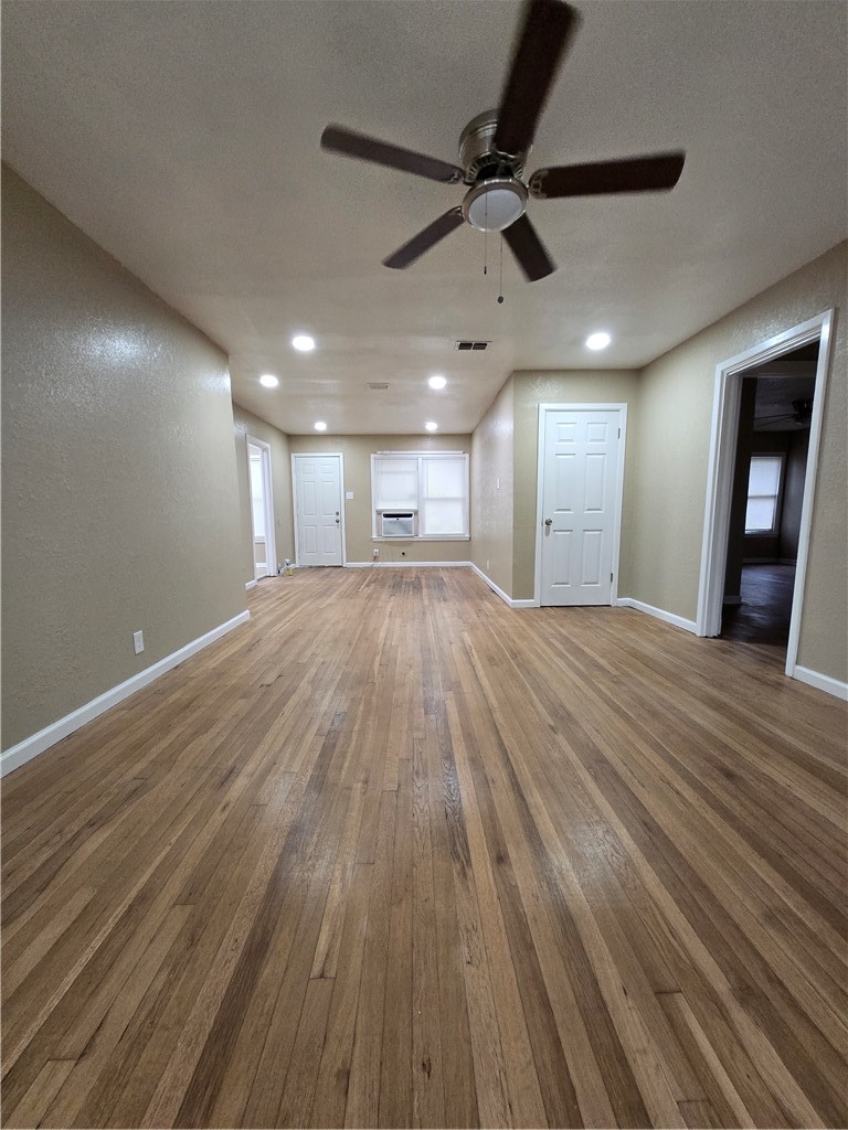 918 Stirman Street Corpus Christi, TX 78411 - Photo 4 of 13 a view of a big room with wooden floor a ceiling fan