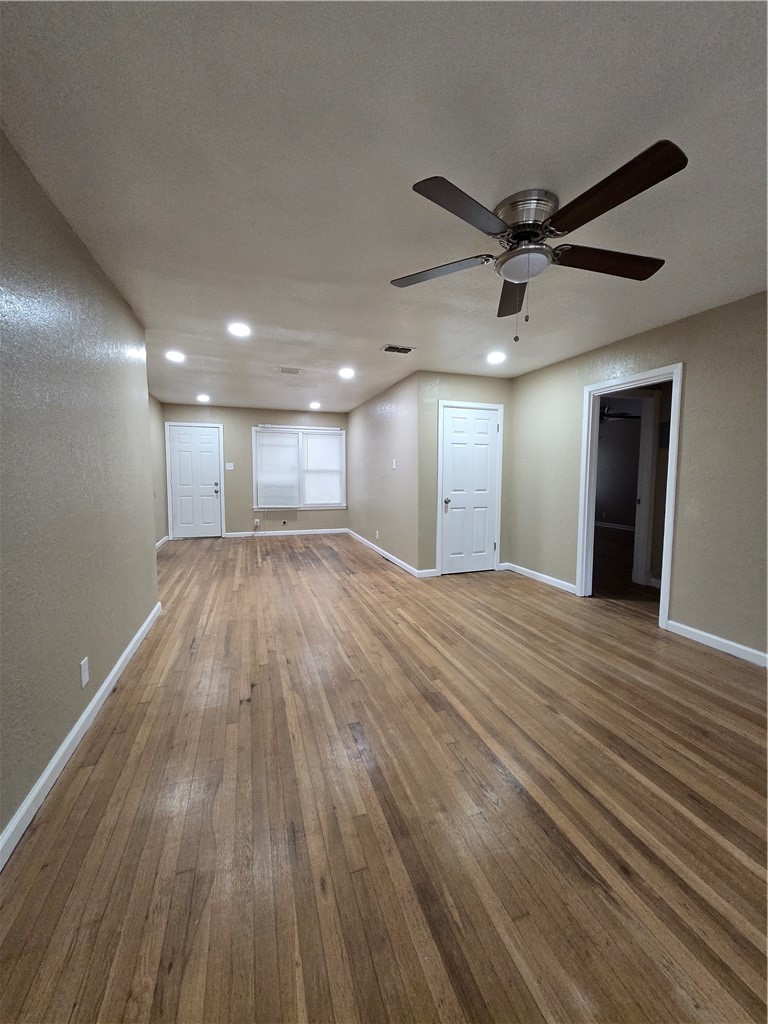 918 Stirman Street Corpus Christi, TX 78411 - Photo 5 of 13 a view of an empty room with wooden floor and a ceiling fan