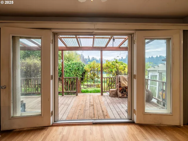 a view of backyard with a large window and wooden floor