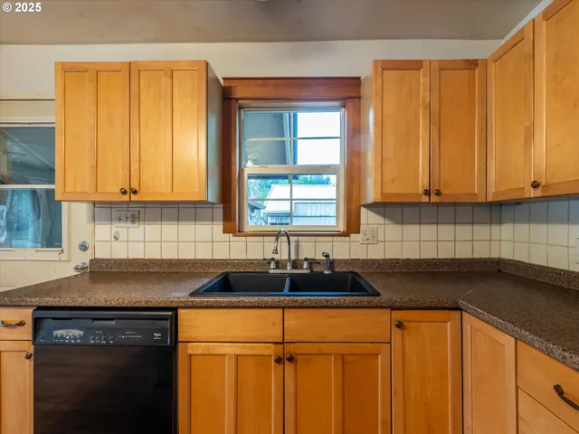 a kitchen with granite countertop white cabinets sink and window