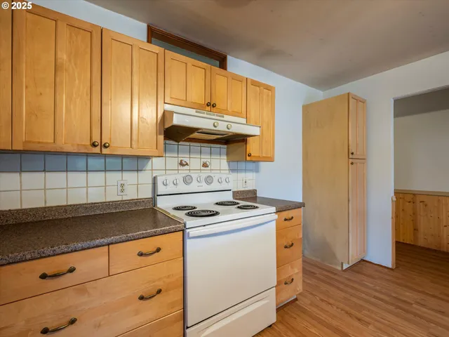 a kitchen with granite countertop wooden cabinets and a stove top oven