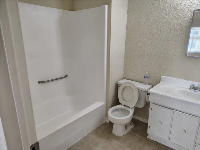 a white toilet sitting next to a bathroom sink and a shower