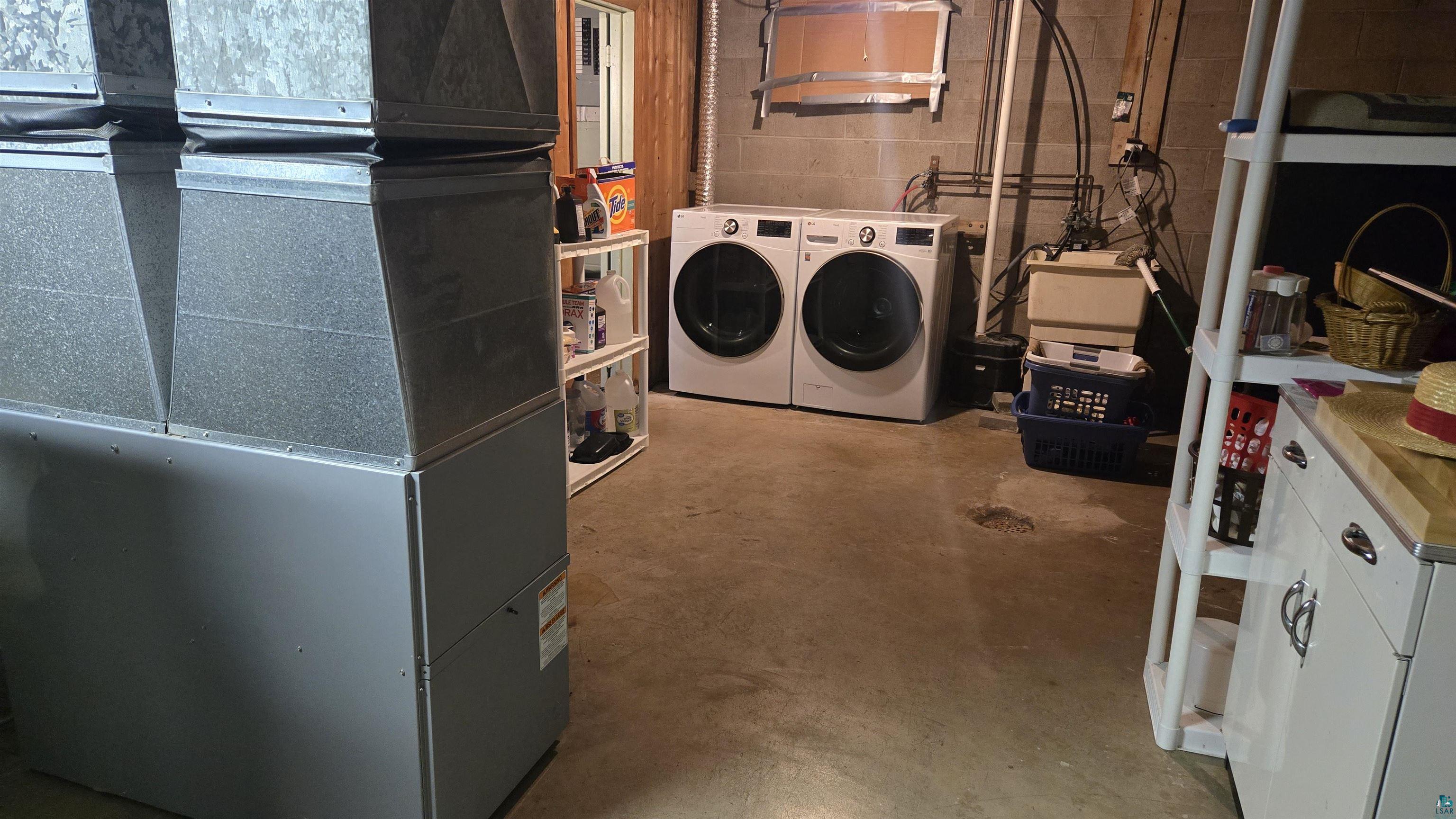 10614 Moose Lake Road Orr, MN 55771 - Photo 34 of 44 Utility space featuring a washer and dryer set, concrete flooring, and exposed block walls