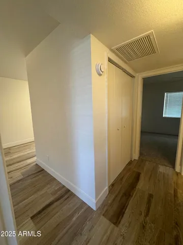 a view of a hallway with wooden floor