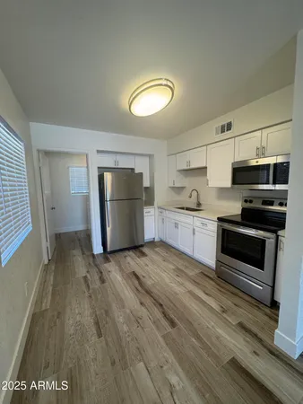 a view of kitchen with sink and refrigerator