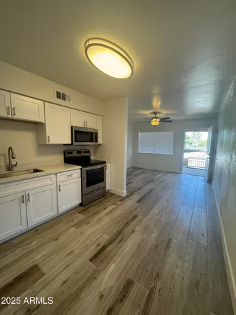 a kitchen with granite countertop a stove a sink and a refrigerator
