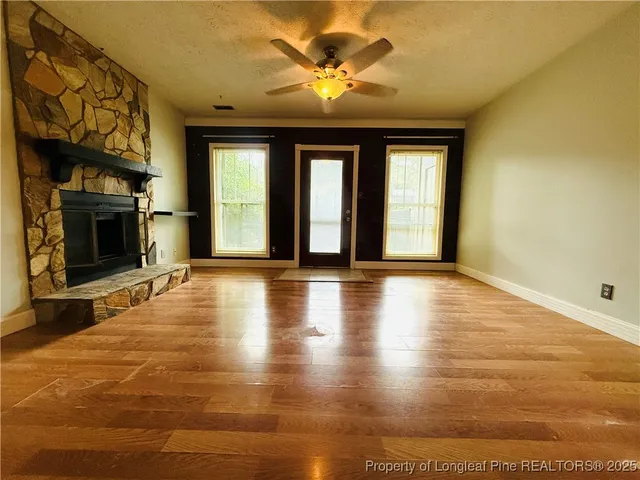 a view of an empty room with a fireplace and a window