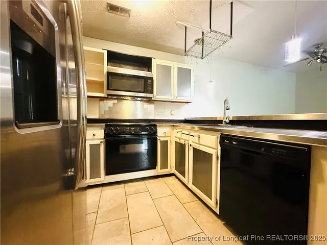 a kitchen with stainless steel appliances granite countertop a stove and a microwave