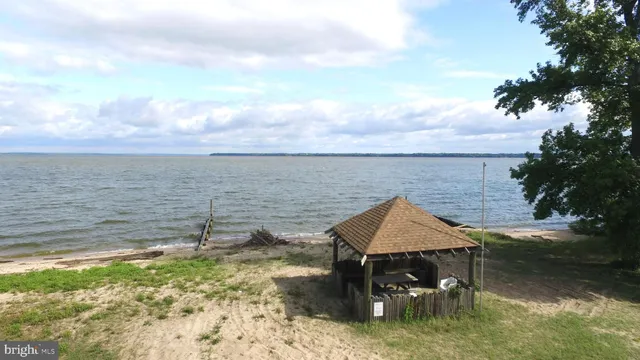 a view of a lake with lawn chairs and iron fence