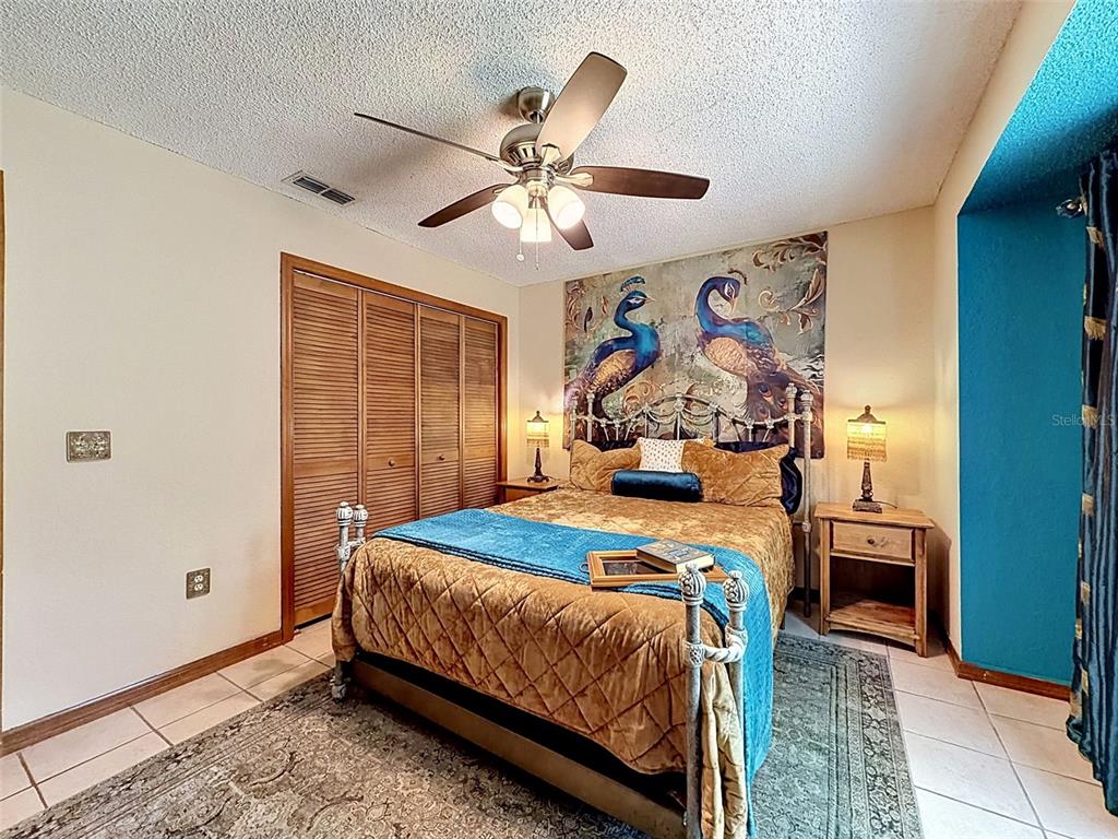 7111 Ricker Avenue Webster, FL 33597 - Photo 24 of 41 a bedroom with a bed and a chandelier