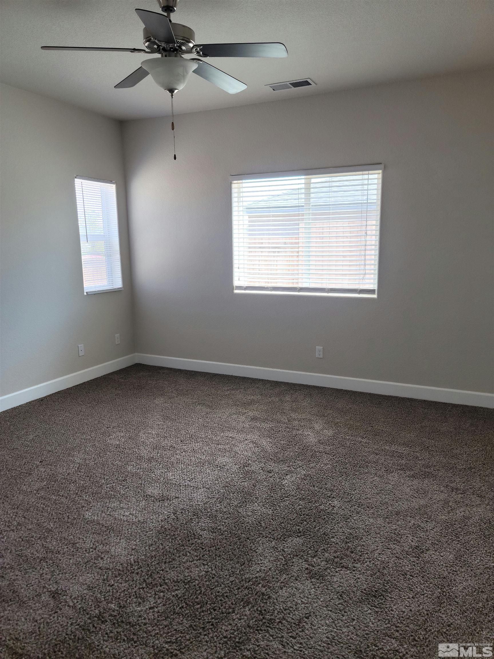 591 White Eagle Lane Fernley, NV 89408 - Photo 17 of 22 an empty room with a window and a fan