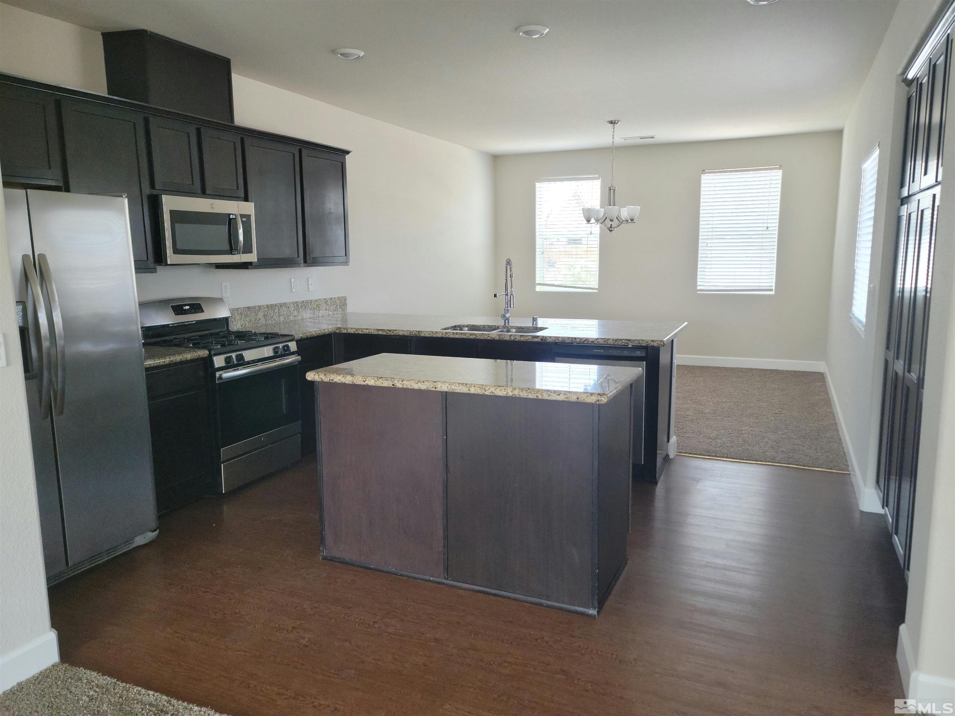 591 White Eagle Lane Fernley, NV 89408 - Photo 3 of 22 a kitchen with stainless steel appliances granite countertop a sink a stove a refrigerator a microwave a sink and dishwasher