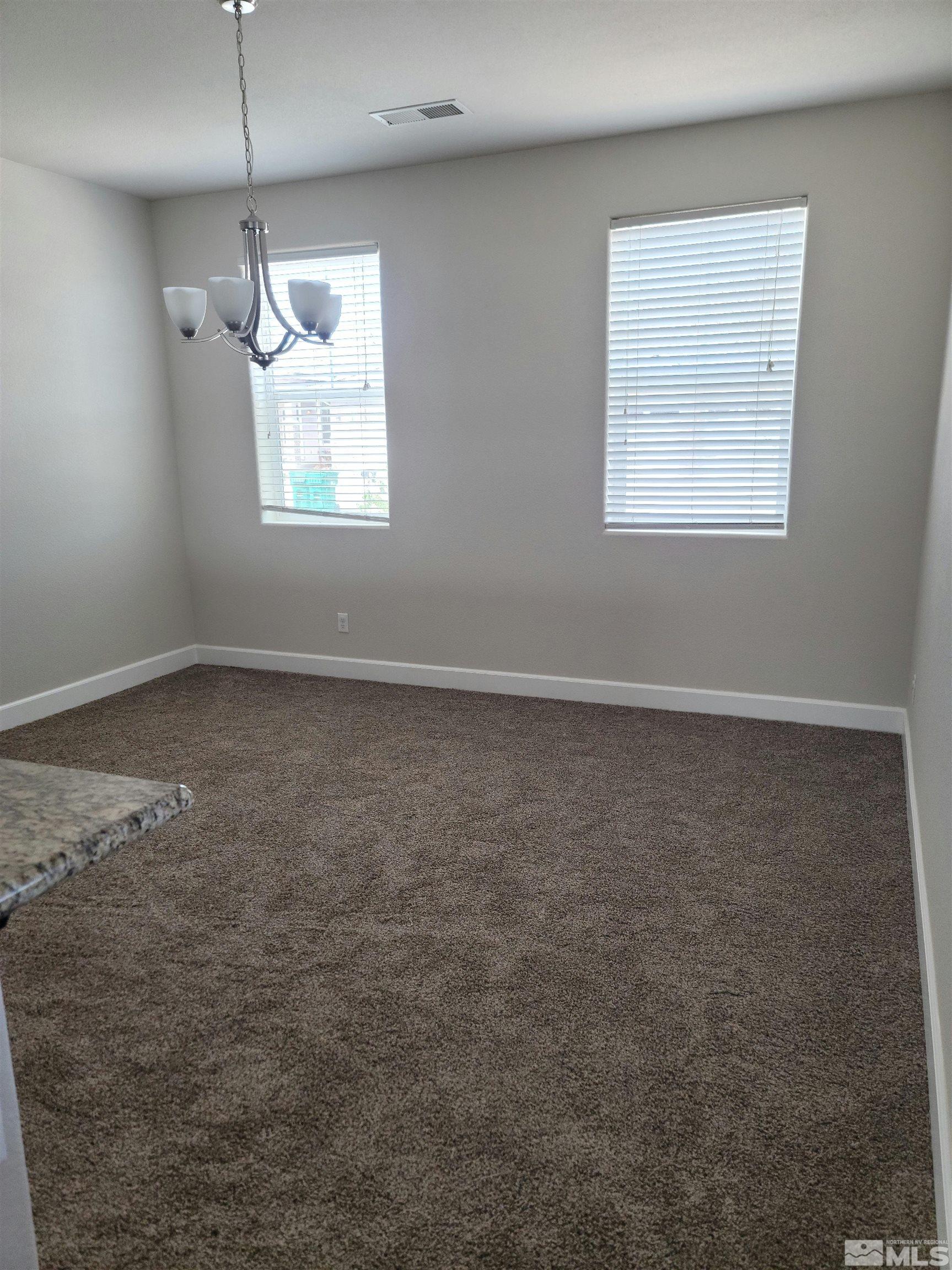 591 White Eagle Lane Fernley, NV 89408 - Photo 5 of 22 an empty room with windows and fan