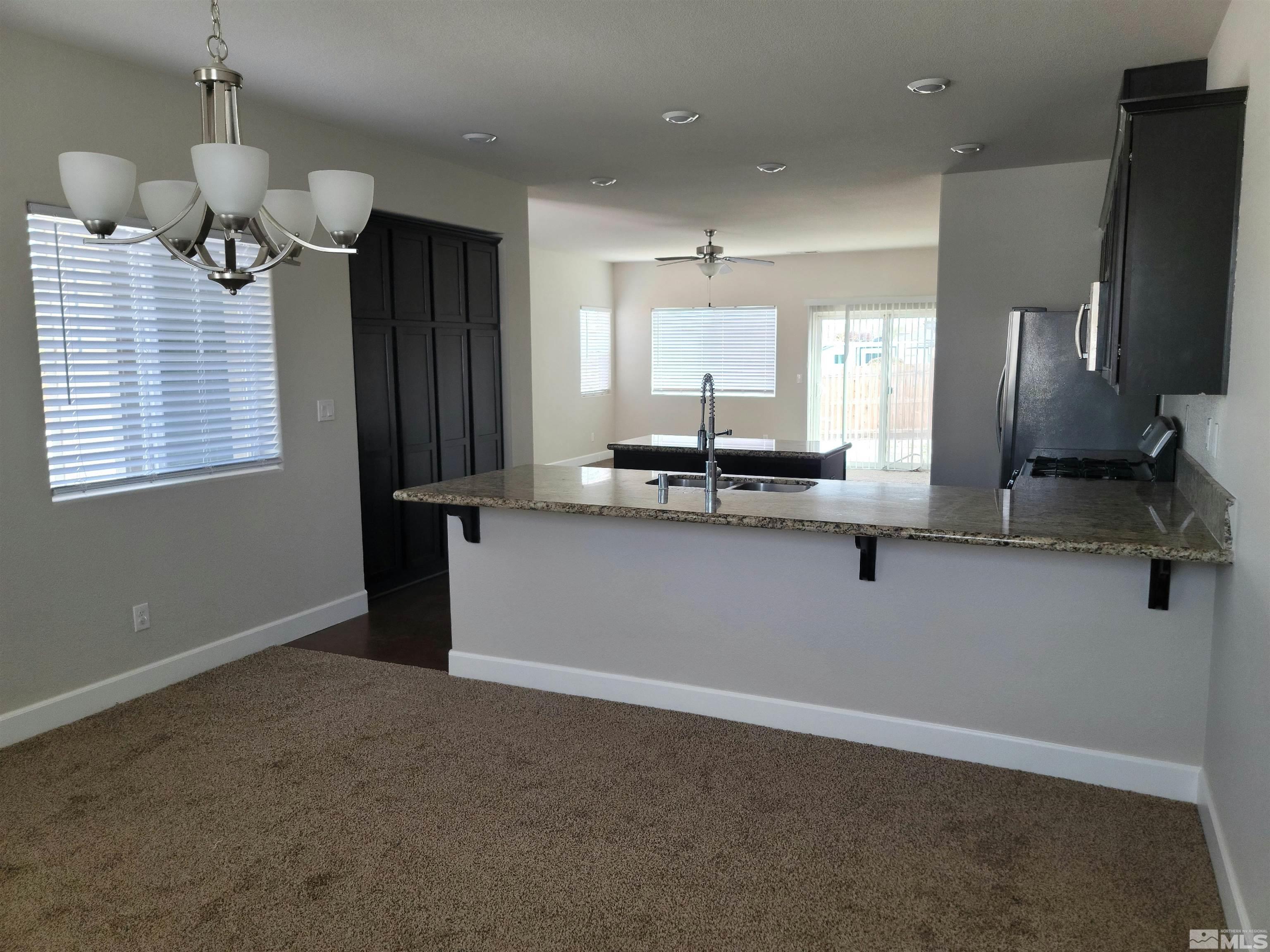 591 White Eagle Lane Fernley, NV 89408 - Photo 6 of 22 a kitchen with kitchen island stainless steel appliances a sink stove and refrigerator