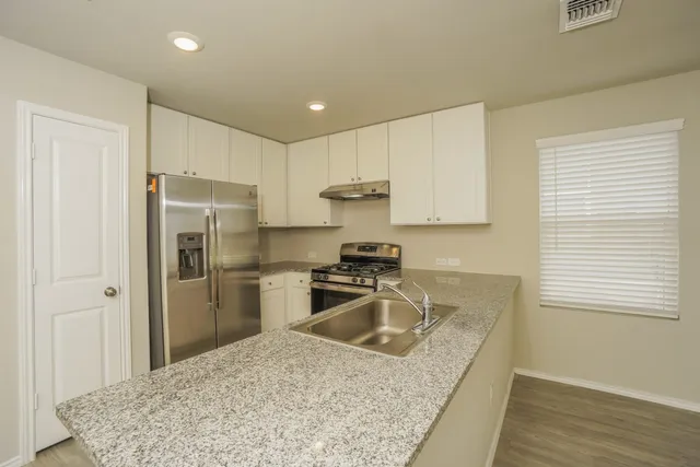 a kitchen with a refrigerator sink and cabinets