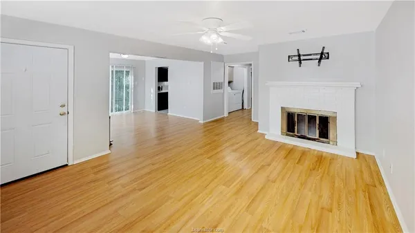 a view of empty room with wooden floor and fireplace