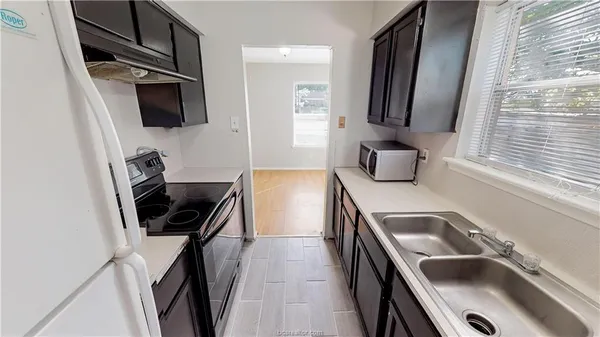 a kitchen with a sink appliances and cabinets