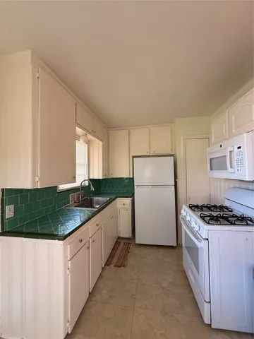 a kitchen with a stove a refrigerator and a sink