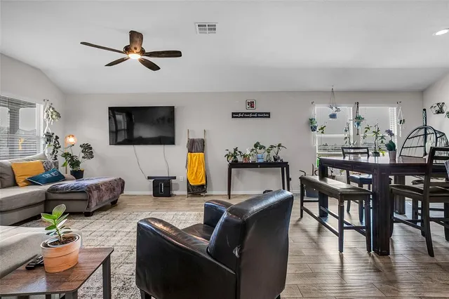 a living room with furniture kitchen view and a flat screen tv
