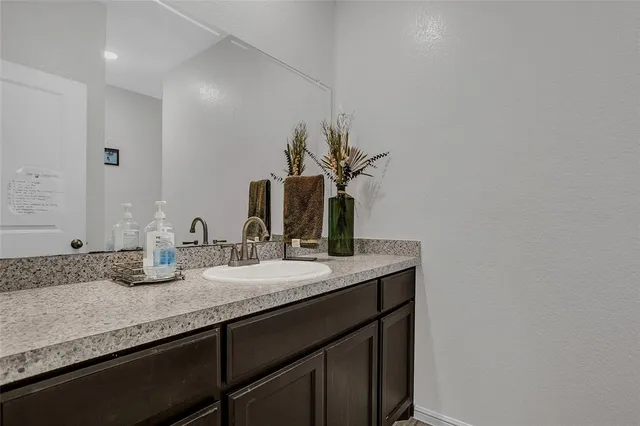 a bathroom with a granite countertop sink and a mirror