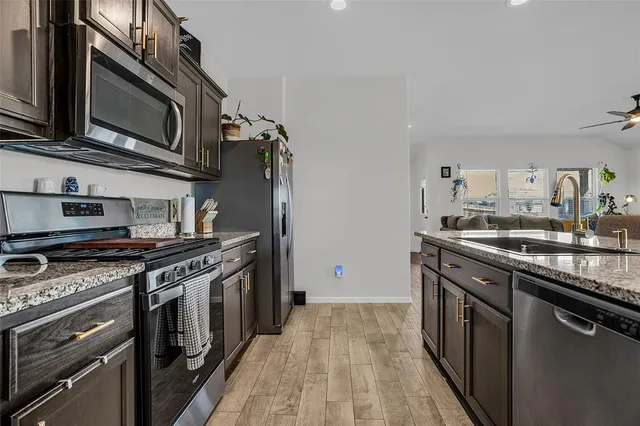 a kitchen with stainless steel appliances granite countertop a stove and a microwave