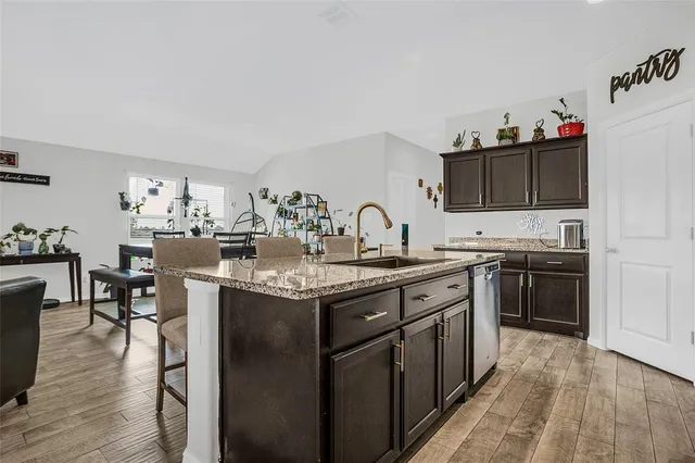 a kitchen with granite countertop a sink stove and cabinets