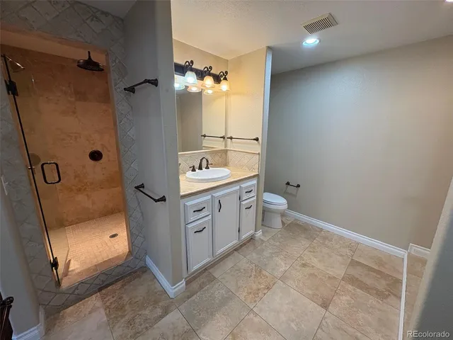 a bathroom with a double vanity sink toilet and shower
