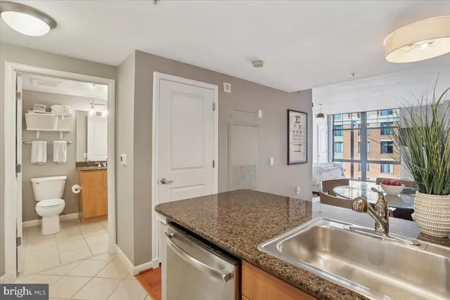 a kitchen with a granite countertop sink and natural light