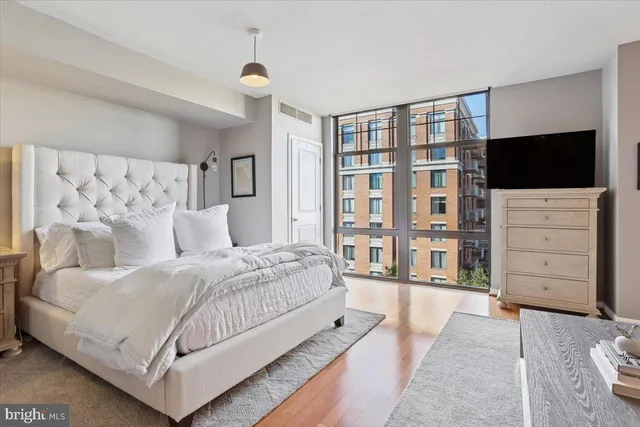 a bedroom with a large bed and a flat tv screen