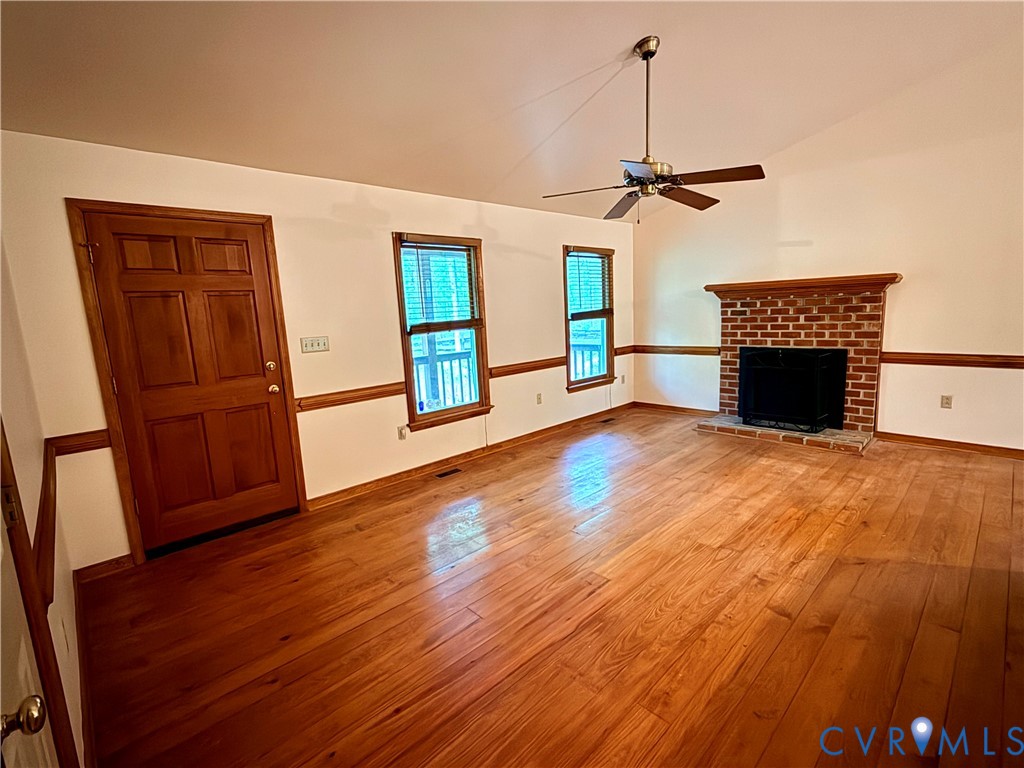 2590 Davis Mill Road Goochland, VA 23063 - Photo 7 of 33 an empty room with wooden floor fireplace and windows