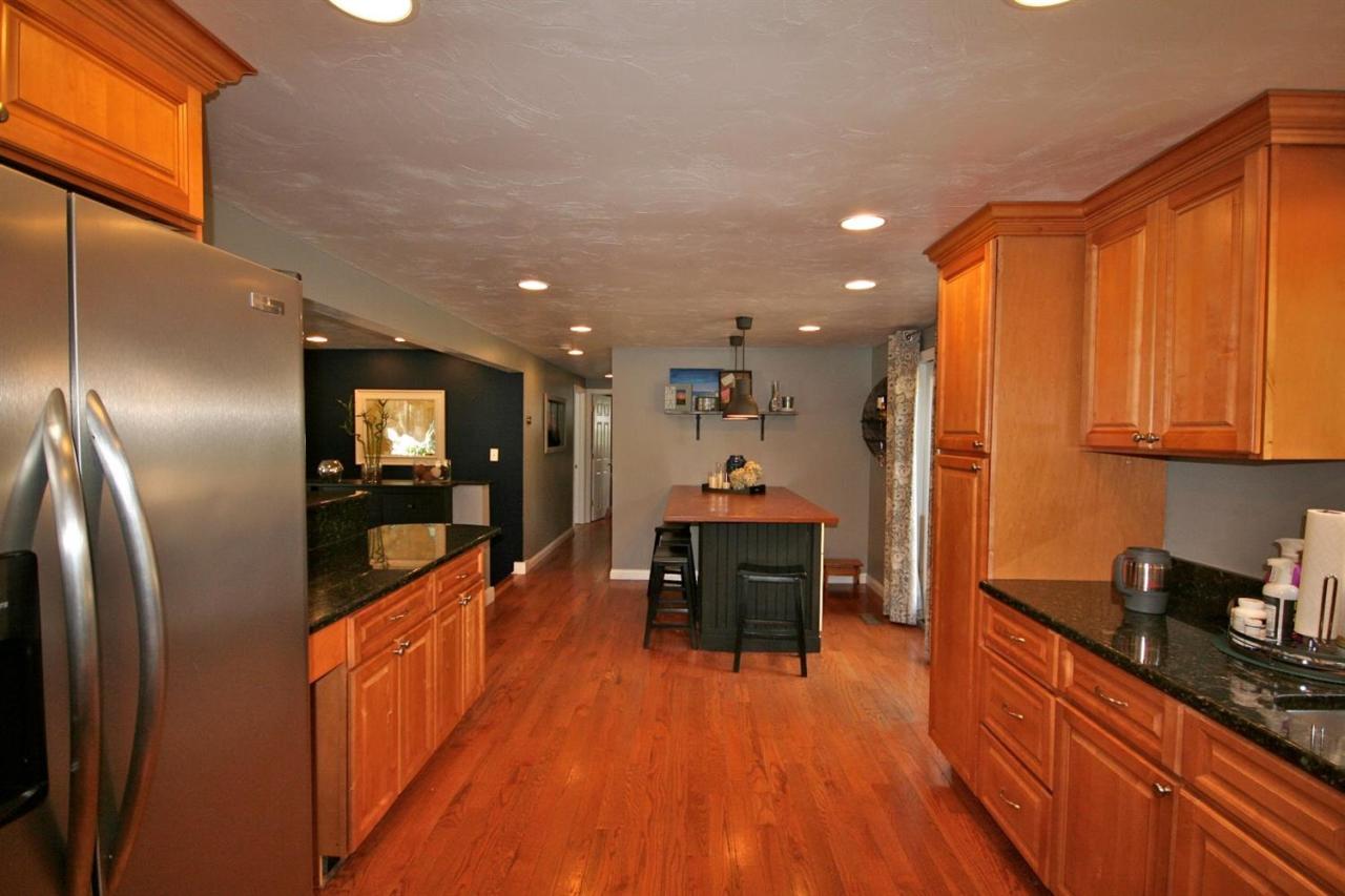 6 Albert Road Pocasset, MA 02559 - Photo 8 of 15 a kitchen with stainless steel appliances granite countertop a refrigerator a stove top oven and a cabinets with wooden floor