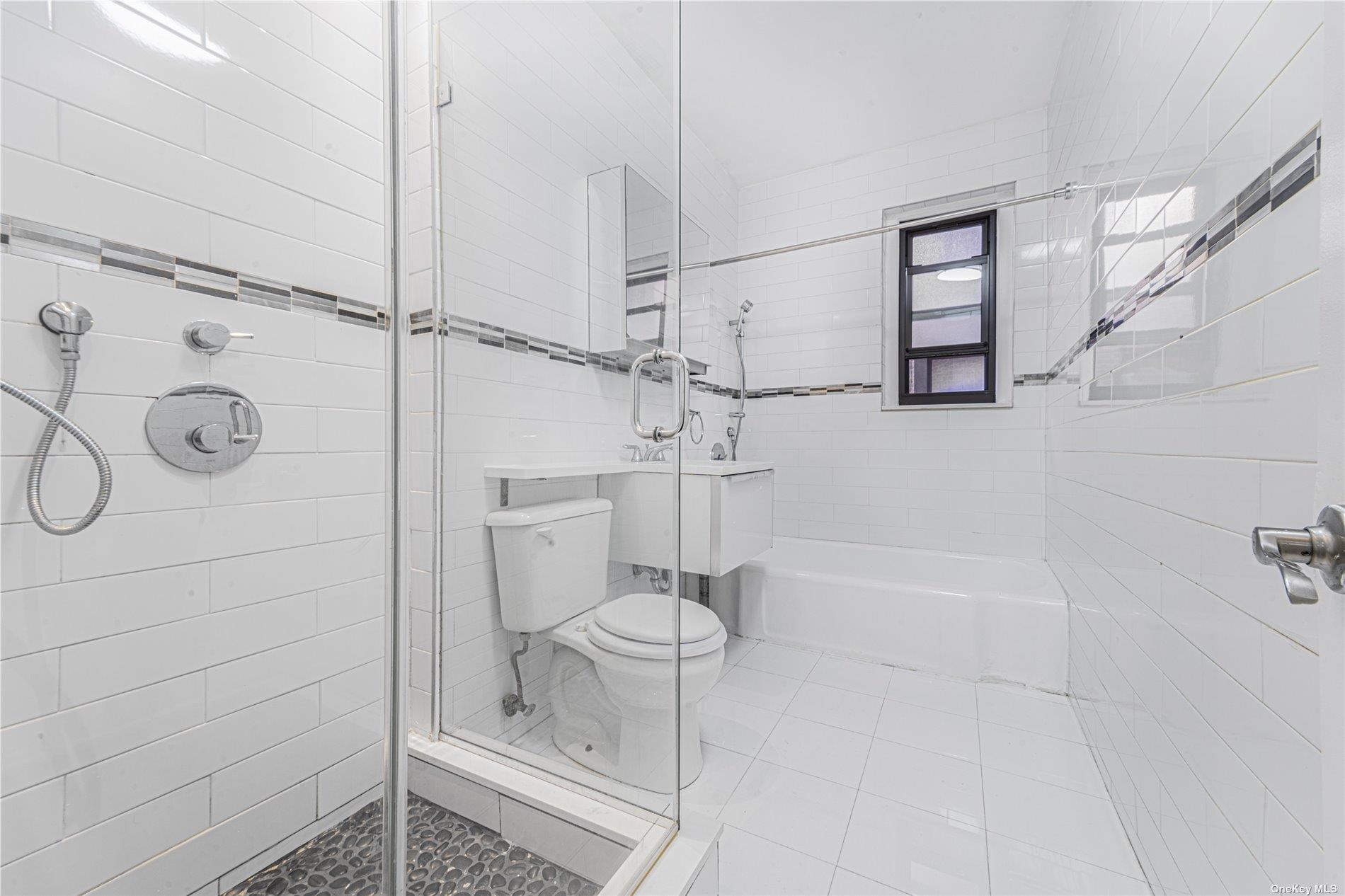 96-11 65th Road, Unit 414 Queens, NY 11374 - Photo 13 of 20 a bathroom with a shower and tub
