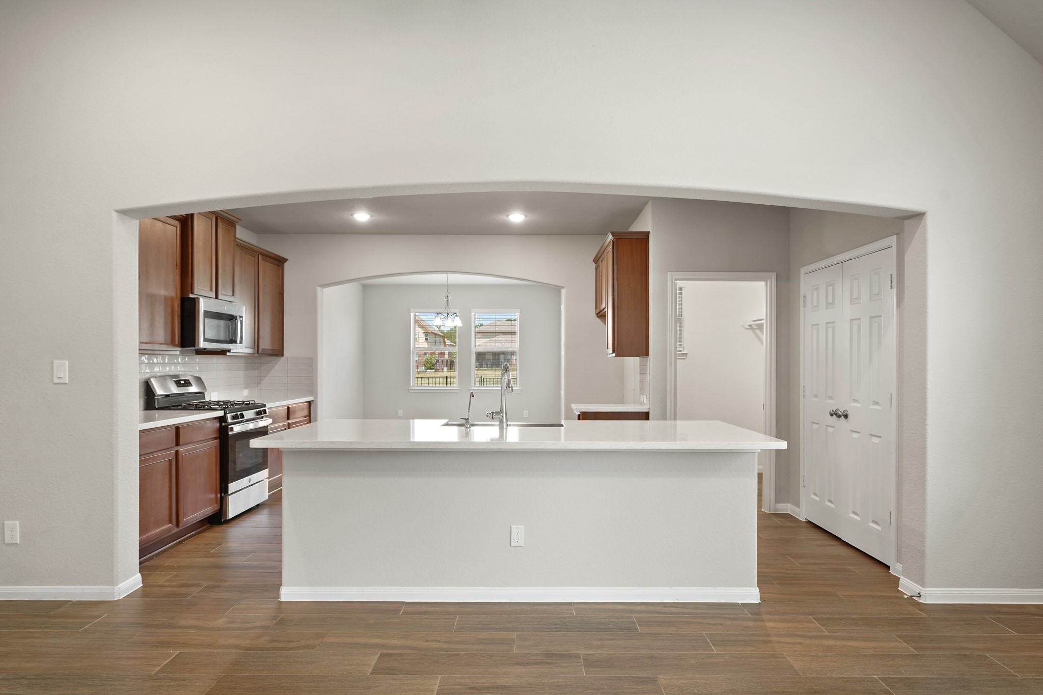 6010 Kolle Drive Rosenberg, TX 77471 - Photo 11 of 45 a kitchen with stainless steel appliances granite countertop a sink a stove and a wooden floors